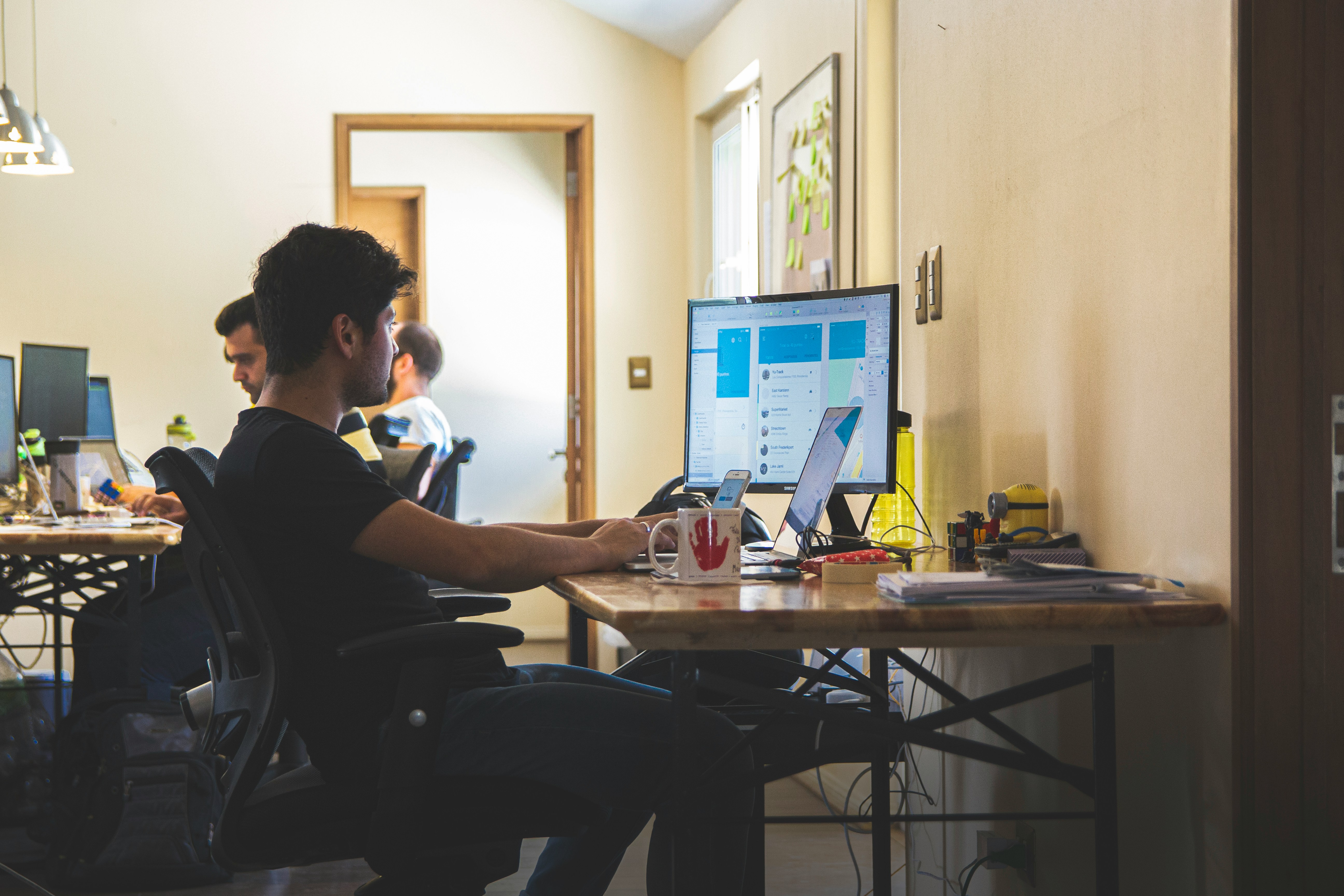 Support agent focused on a ticket dashboard at their desk in a busy office